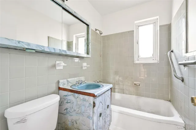 a bathroom with a granite countertop sink a toilet and bathtub