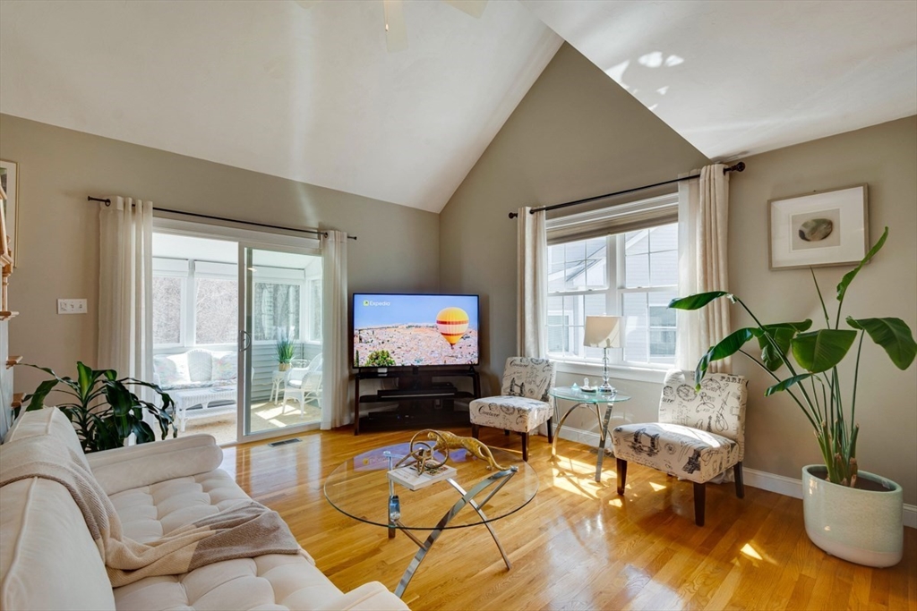 98 Summer Road, Unit 98 Boxborough, MA 01719 - Photo 11 of 27 a living room with furniture a flat screen tv and a large window