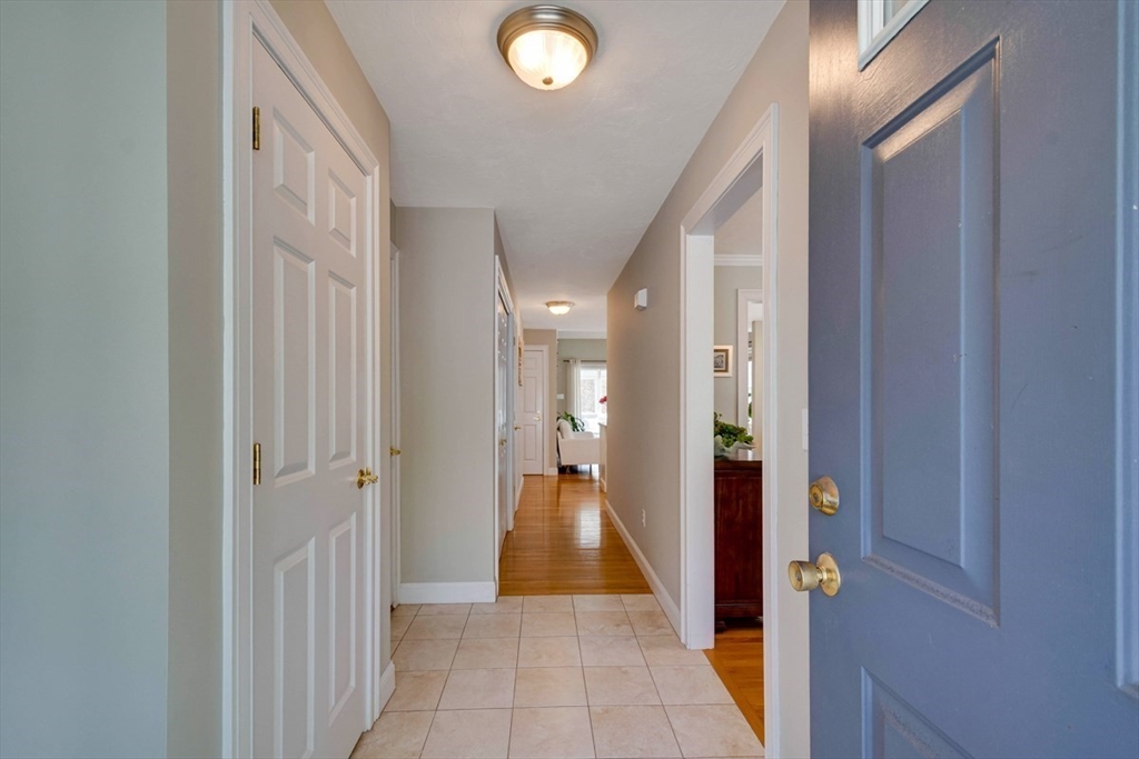 98 Summer Road, Unit 98 Boxborough, MA 01719 - Photo 2 of 27 a view of a hallway with wooden floor and a livingroom with a bathroom