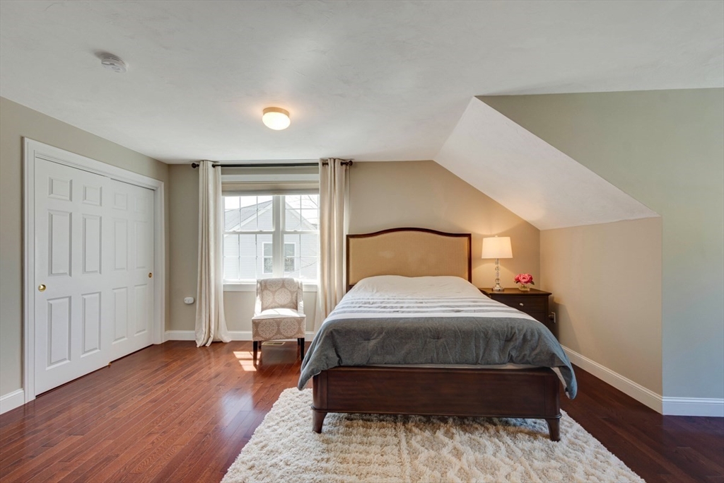 98 Summer Road, Unit 98 Boxborough, MA 01719 - Photo 22 of 27 a bedroom with a bed and wooden floor