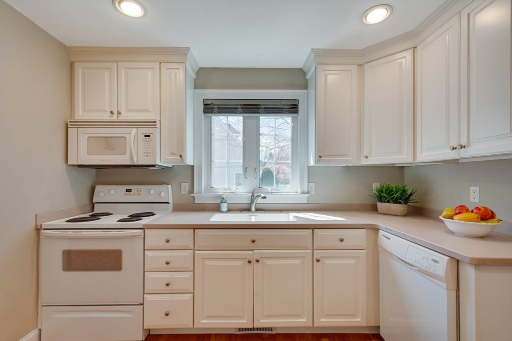 98 Summer Road, Unit 98 Boxborough, MA 01719 - Photo 9 of 27 a kitchen with white cabinets and white appliances