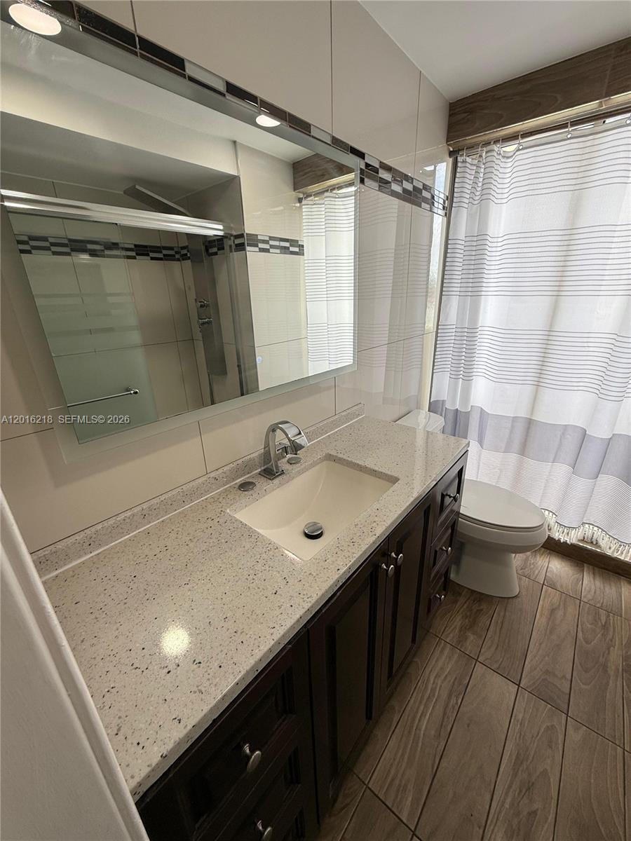 9321 Southwest 4th Street, Unit 230C Miami, FL 33174 - Photo 26 of 37 a bathroom with a sink a toilet a mirror and shower