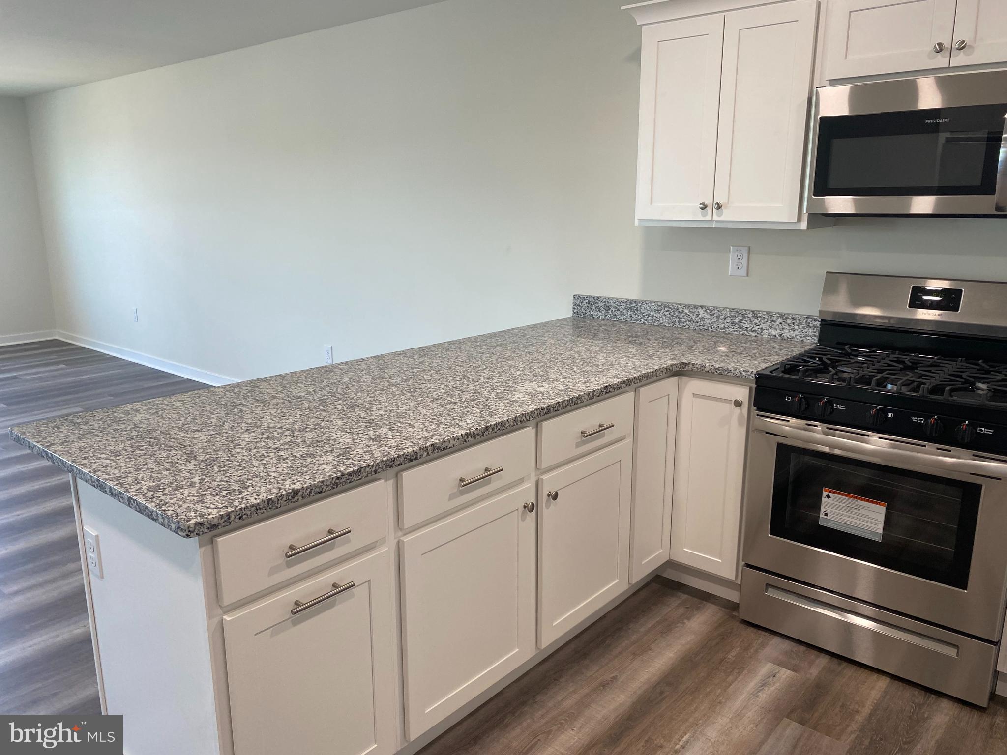 3852 Ridge Pike, Unit 3852 Collegeville, PA 19426 - Photo 13 of 24 a kitchen with granite countertop a stove and a sink