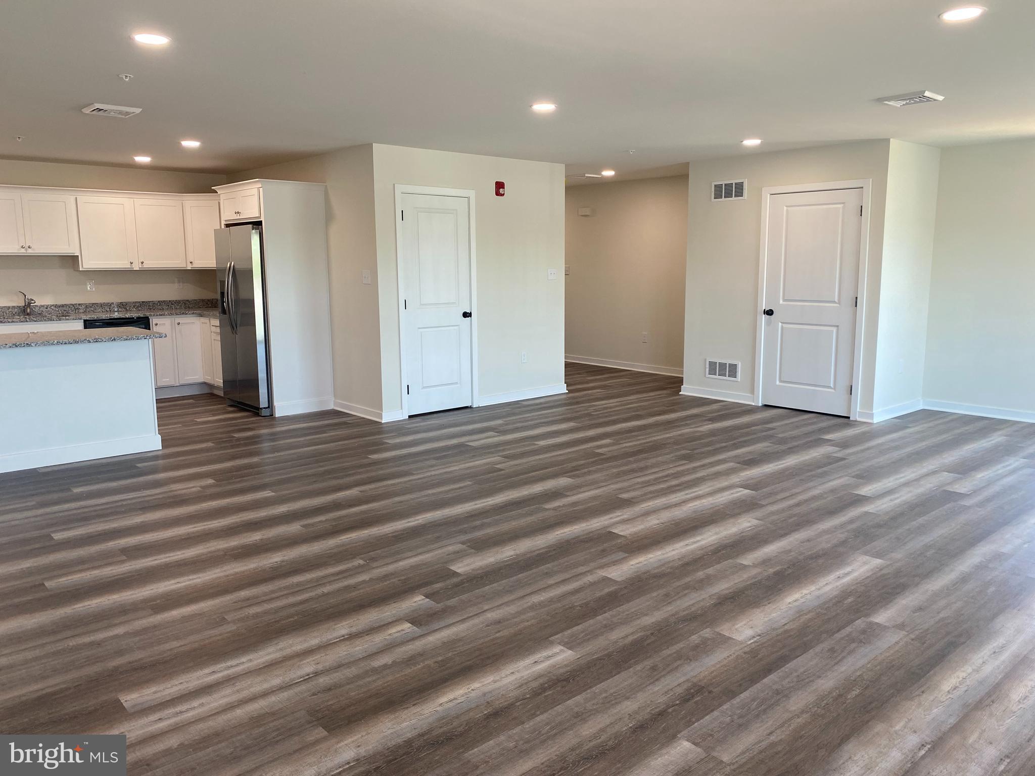 3852 Ridge Pike, Unit 3852 Collegeville, PA 19426 - Photo 5 of 24 a view of an empty room with wooden floor and a kitchen