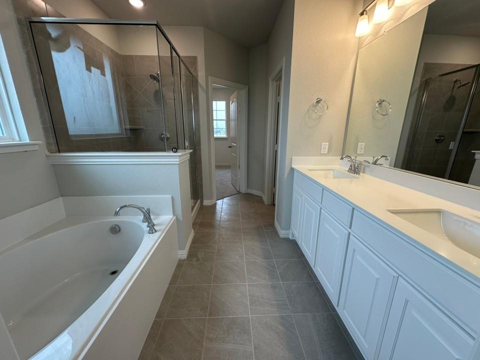 2472 Black Jack Oak Road Terrell, TX 75161 - Photo 17 of 27 a bathroom with a bathtub a double vanity sink and mirror