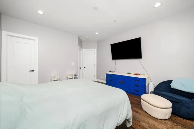 a spacious bedroom with a bed and a flat screen tv
