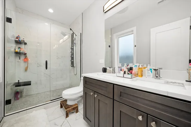 a bathroom with a sink a toilet and shower