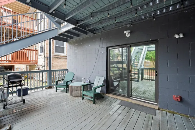 a roof deck with table and chairs and wooden floor