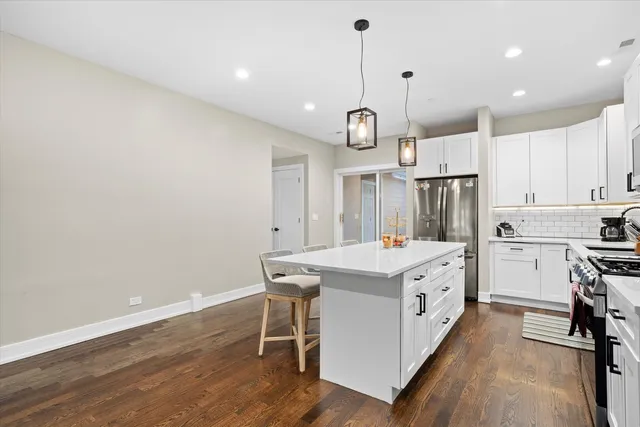 a kitchen that has a lot of cabinets in it and wooden floors