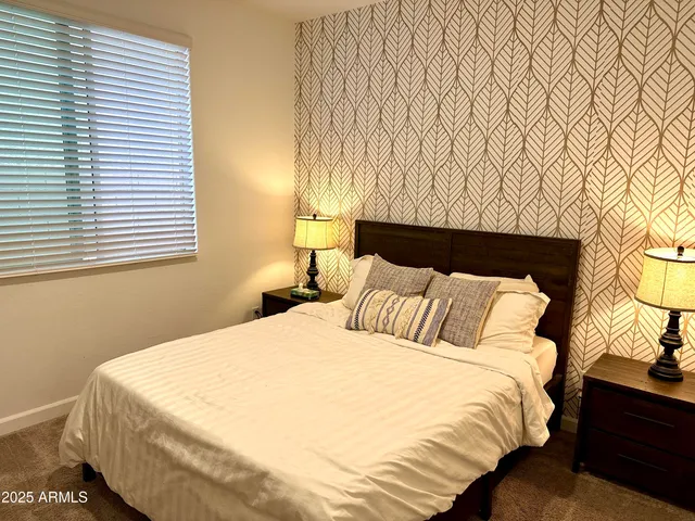 a bedroom with a bed and a night stand