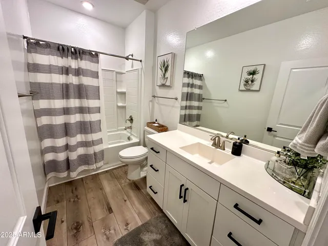 a bathroom with a double vanity sink toilet and shower