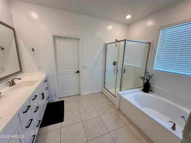 a bathroom with a granite countertop sink a mirror and shower