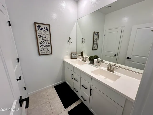a bathroom with a double vanity sink mirror and