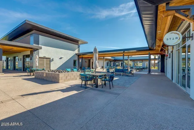 a view of a big building with table and chairs
