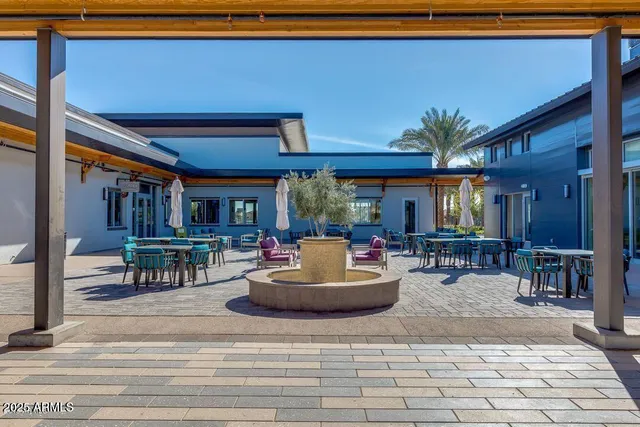 a living room with furniture a dining table and chairs with potted plants