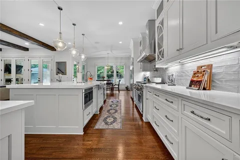 a kitchen with stainless steel appliances cabinets and wooden floor