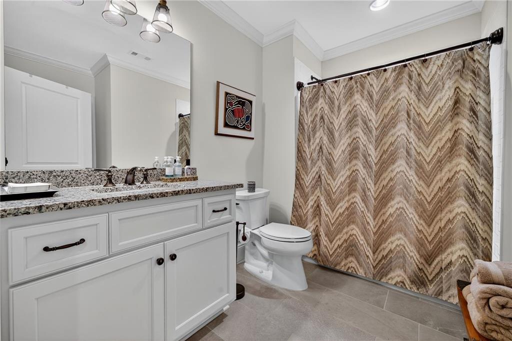 976 Ferncliff Road Northeast Atlanta, GA 30324 - Photo 49 of 58 a bathroom with a granite countertop sink a toilet and a mirror