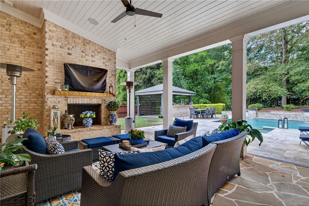 976 Ferncliff Road Northeast Atlanta, GA 30324 - Photo 50 of 58 a outdoor space with patio fireplace couches and a dining table with garden view