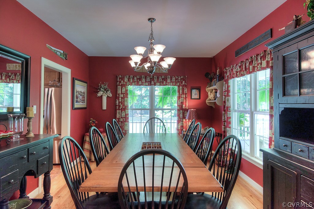 3480 Courtland Road Disputanta, VA 23842 - Photo 14 of 37 a view of a dining room with furniture a chandelier and large windows