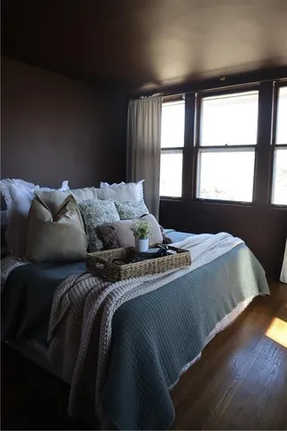 a bed sitting in a bedroom next to a window