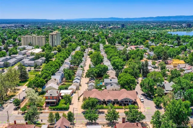 an aerial view of residential houses with outdoor space and trees