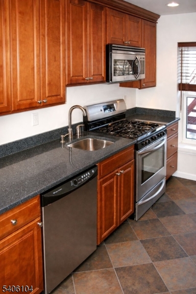18 Springfield Avenue, Unit 4E Cranford, NJ 07016 - Photo 7 of 11 a kitchen with stainless steel appliances granite countertop a stove a sink and a microwave