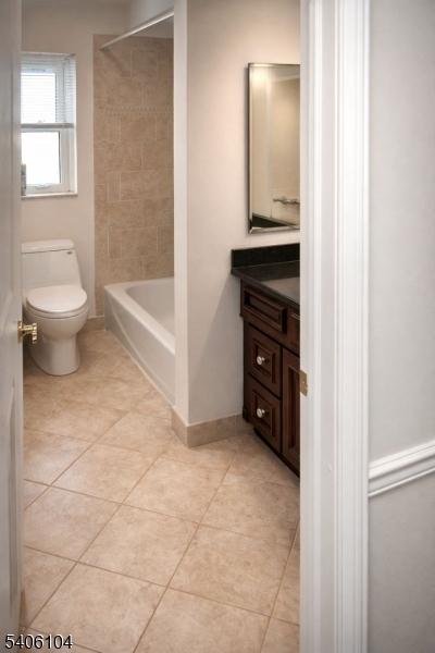 18 Springfield Avenue, Unit 4E Cranford, NJ 07016 - Photo 9 of 11 a bathroom with a granite countertop sink a toilet and a mirror