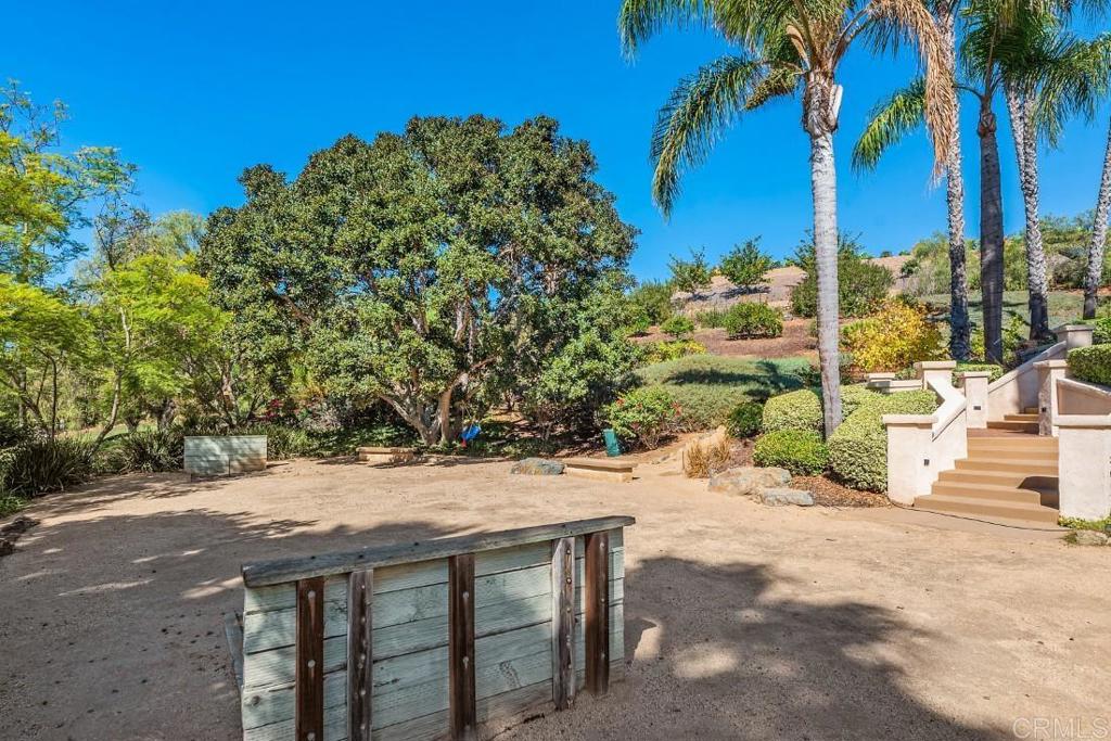 7345 Vista Rancho Court Rancho Santa Fe, CA 92091 - Photo 46 of 71 a view of a patio with a table and chairs under an umbrella