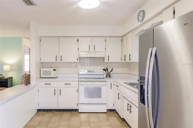 a kitchen with white cabinets and white appliances