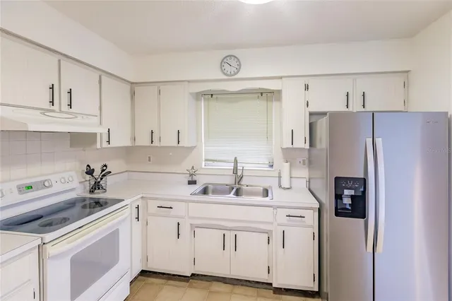 a kitchen with white cabinets and white appliances