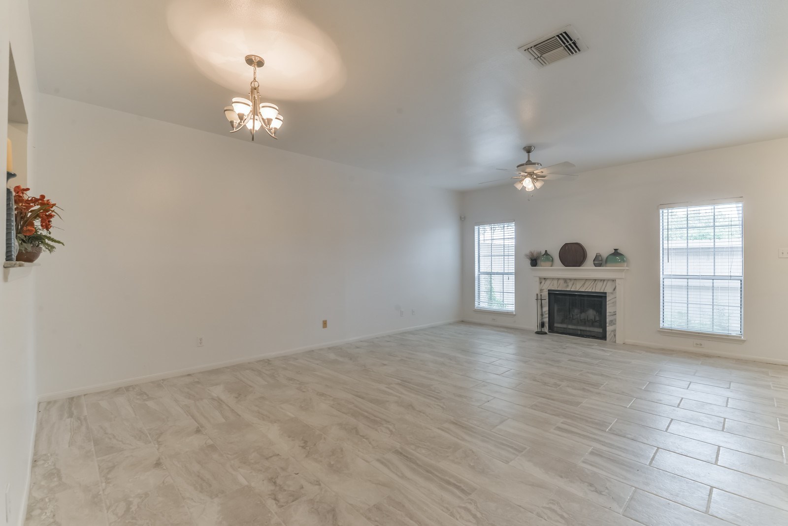 3126 Holly Hall Street Houston, TX 77054 - Photo 6 of 36 Living and dining area has tile floors, a wood burning fireplace, windows that overlook the patio/courtyard, a ceiling fan and light fixture mounted over the dining area.