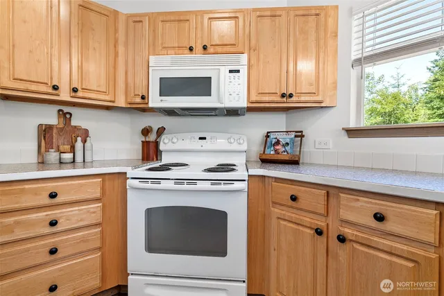 a kitchen with granite countertop white cabinets stainless steel appliances and sink