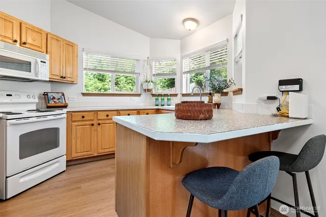 a kitchen with a table chairs sink and wooden floor