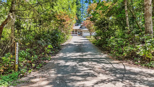 a front view of a house with a yard and trees