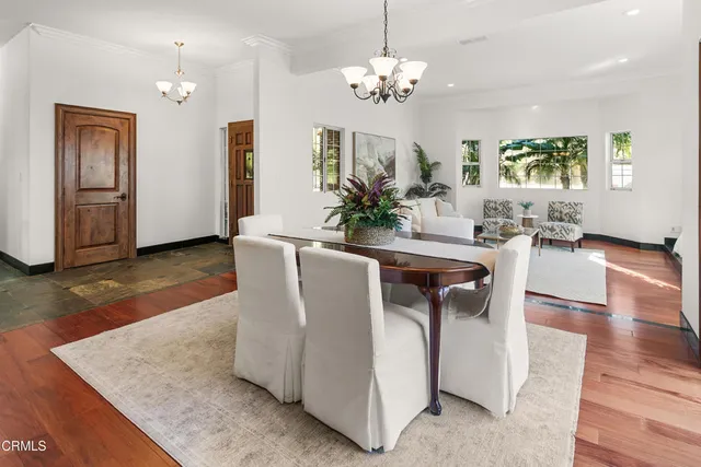 a kitchen with stainless steel appliances kitchen island granite countertop a table chairs and a refrigerator
