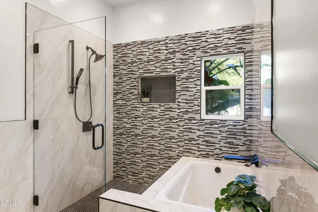 a bathroom with a double vanity sink a mirror and a bathtub