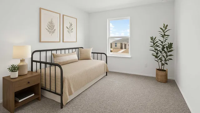 a spacious bedroom with a bed and a potted plant