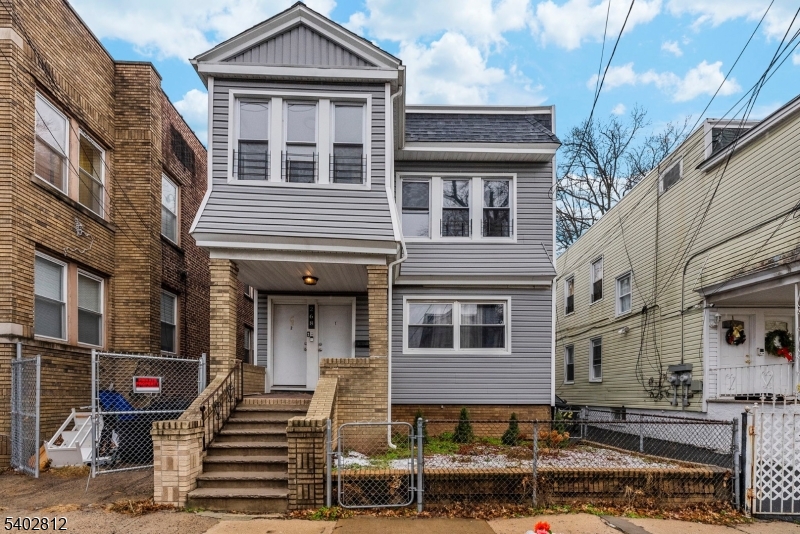 268 Leslie Street Newark, NJ 07112 - Photo 1 of 12 a front view of a residential apartment building with a yard