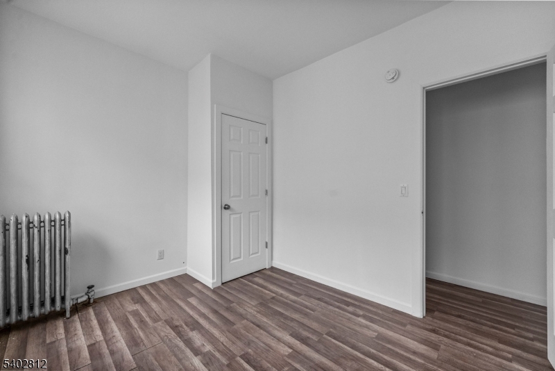 268 Leslie Street Newark, NJ 07112 - Photo 4 of 12 a view of an empty room with wooden floor and a window