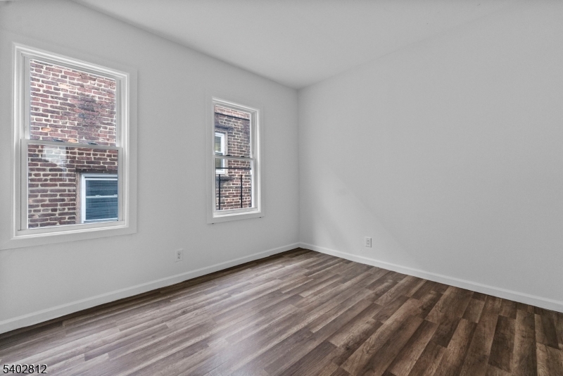 268 Leslie Street Newark, NJ 07112 - Photo 6 of 12 a view of an empty room with wooden floor and a window