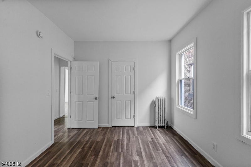 268 Leslie Street Newark, NJ 07112 - Photo 7 of 12 a view of an empty room with wooden floor and a window