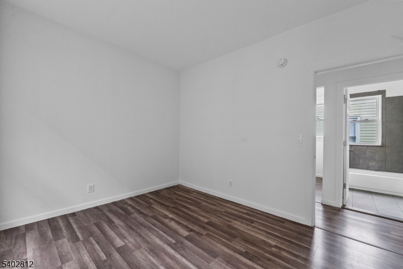 268 Leslie Street Newark, NJ 07112 - Photo 8 of 12 a view of a room with wooden floor and white walls