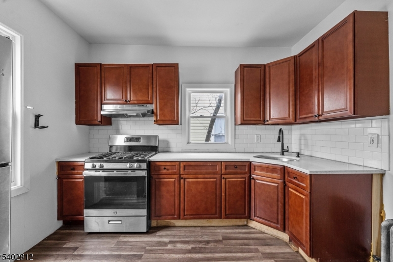 268 Leslie Street Newark, NJ 07112 - Photo 9 of 12 a kitchen with stainless steel appliances a stove sink and cabinets