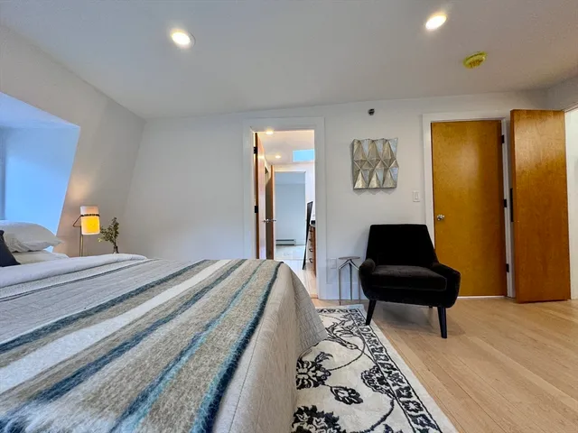 a bedroom with a bed and wooden floor