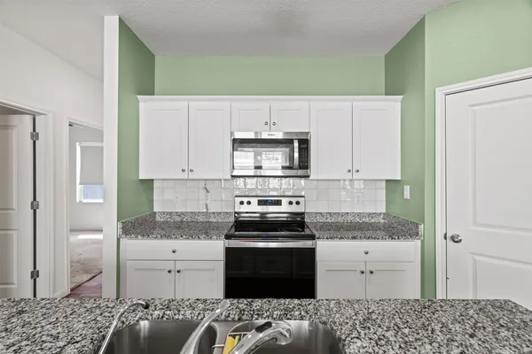 a kitchen with kitchen island stainless steel appliances a refrigerator and cabinets