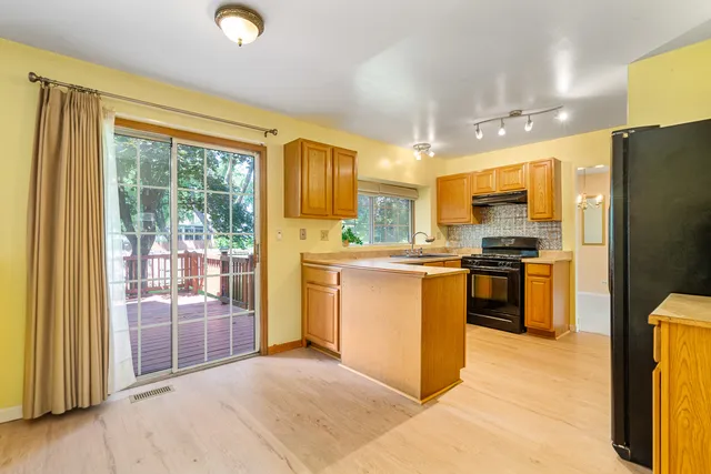 a kitchen with a refrigerator a stove top oven a sink and a large window