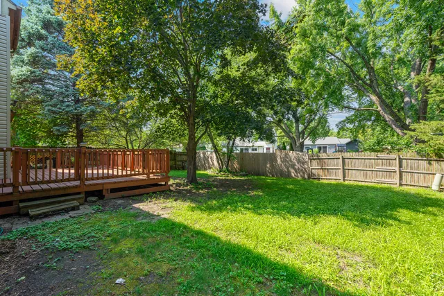 a front view of a house with a garden and trees