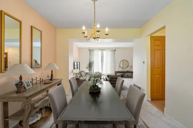 a view of a dining room with furniture and chandelier