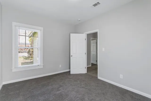 an empty room with windows and closet