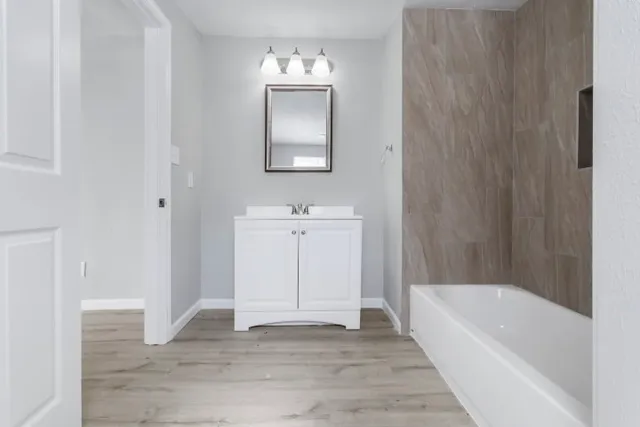a bathroom with a tub shower and a sink